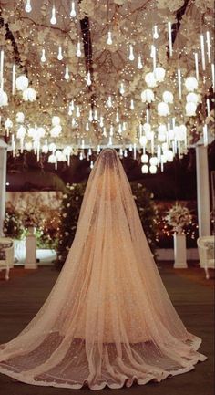 the back of a bridal gown in front of a chandelier