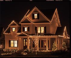 a large house with christmas lights on the front and side of it's windows