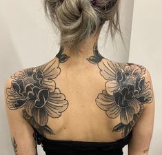 a woman with tattoos on her back and shoulder