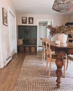 a wooden table sitting on top of a rug in a living room next to a doorway