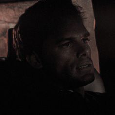 a man sitting in the back seat of a car at night looking off into the distance