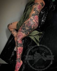 a woman with tattoos on her legs sitting in a chair