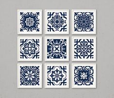 six blue and white tile designs on a gray wall, each with an intricate design