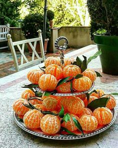 there are many oranges stacked on top of each other in this plate, and one is still attached to the table