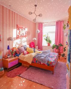 a bedroom decorated in pink and purple with lots of decorations on the walls, flooring and bedding