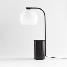 a black table lamp with a white ball on the top and an oval light shade