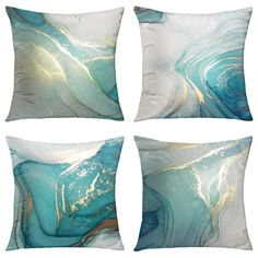 four square pillows with blue and gold designs on the front, one has a white background