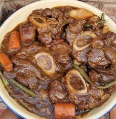 a white bowl filled with meat and vegetables