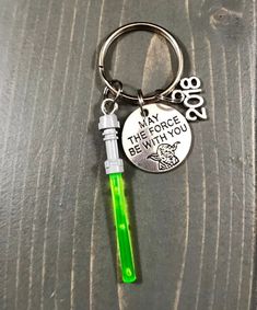 a keychain with a green light on it and a message that says may the force be with you