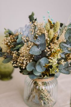 a vase filled with lots of flowers on top of a table