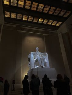 the lincoln memorial is lit up at night with people standing around looking on and taking pictures