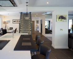 a kitchen and living room with stairs leading up to the second floor, in an open concept home