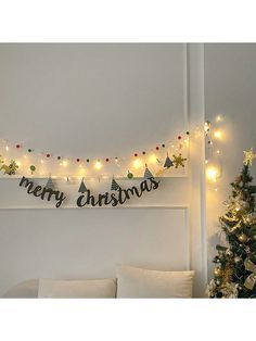 christmas lights are hanging on the wall above a bed