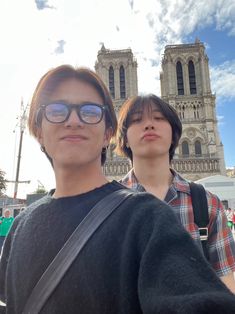 two people standing next to each other in front of a cathedral