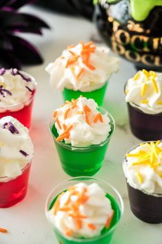 cupcakes with white frosting and sprinkles are arranged on a table