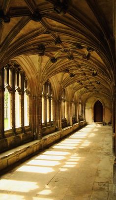 the sun is shining in an old building with stone arches and arched windows on both sides