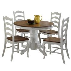 a white table with four chairs and a yellow pitcher