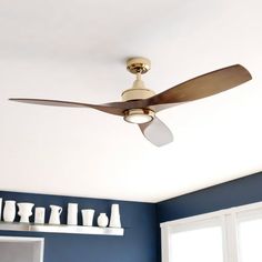 a ceiling fan in a room with blue walls and white shelves on either side of it