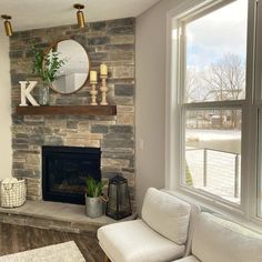 a living room filled with furniture and a fire place in front of a large window