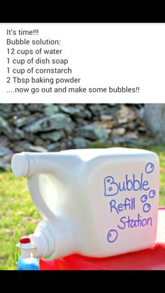 a bottle of bubble refill sitting on top of a red table in the grass