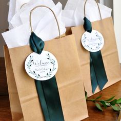 two brown paper bags with green ribbons on them