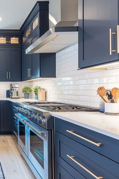 a kitchen with blue cabinets and white counter tops, stainless steel appliances and wooden flooring