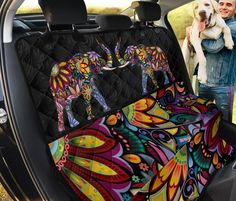 a woman holding a dog in her car seat cover with colorful flowers and butterflies on it