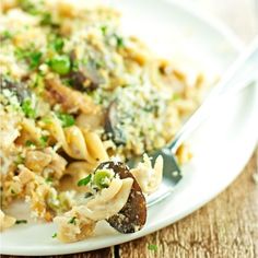 a white plate topped with pasta and mushrooms