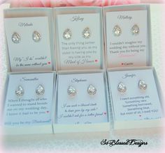 four pairs of diamond earrings are shown in the box with pink flowers behind them and on top of each other