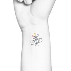 a white wrist tattoo with flowers on it and a band aids sticker attached to the wrist