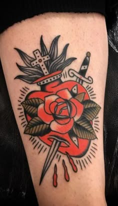 a rose and dagger tattoo on the leg