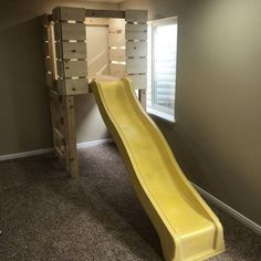 a yellow slide in the corner of a room