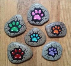 four painted rocks with paw prints on them