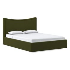 a bed with a green headboard and white pillows