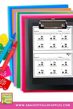 a clipboard with numbers on it next to colored paper and scissors for addition practice