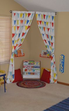 a child's playroom with colorful curtains and rugs on the floor in front of it