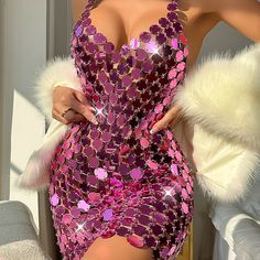 a woman in a pink sequin dress posing for the camera