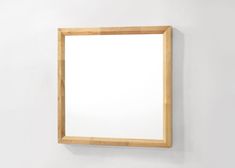 a wooden frame hanging on the wall with a white background and light wood trim around it