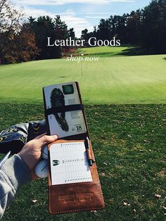 a person holding a notebook and pen in their hand with the title leather goods shop now