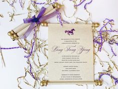 a scroll with a purple ribbon on it next to some confetti