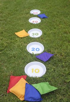 some paper plates are laying on the grass with numbers painted on them and one is in the middle