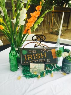 the irish pub sign is surrounded by flowers and other decorations on a white table cloth