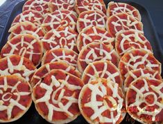 many small pizzas with white toppings are on a black tray and ready to be eaten