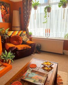 a living room filled with furniture next to a painting on the wall and a window