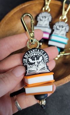 a person is holding some books in their hand and they are wearing keychains