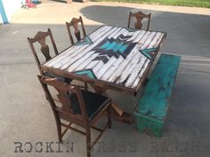 an old table and chairs are sitting on the cement ground with graffiti painted on them