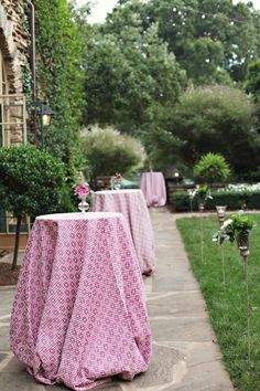 tables covered with pink tablecloths sit in the middle of an outdoor patio area