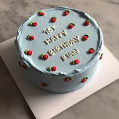 a birthday cake with white frosting and strawberries on it