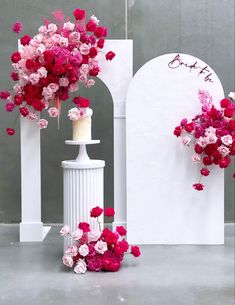 pink and red flowers are on top of a white pedestal