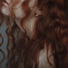 a woman with long red hair is staring at something